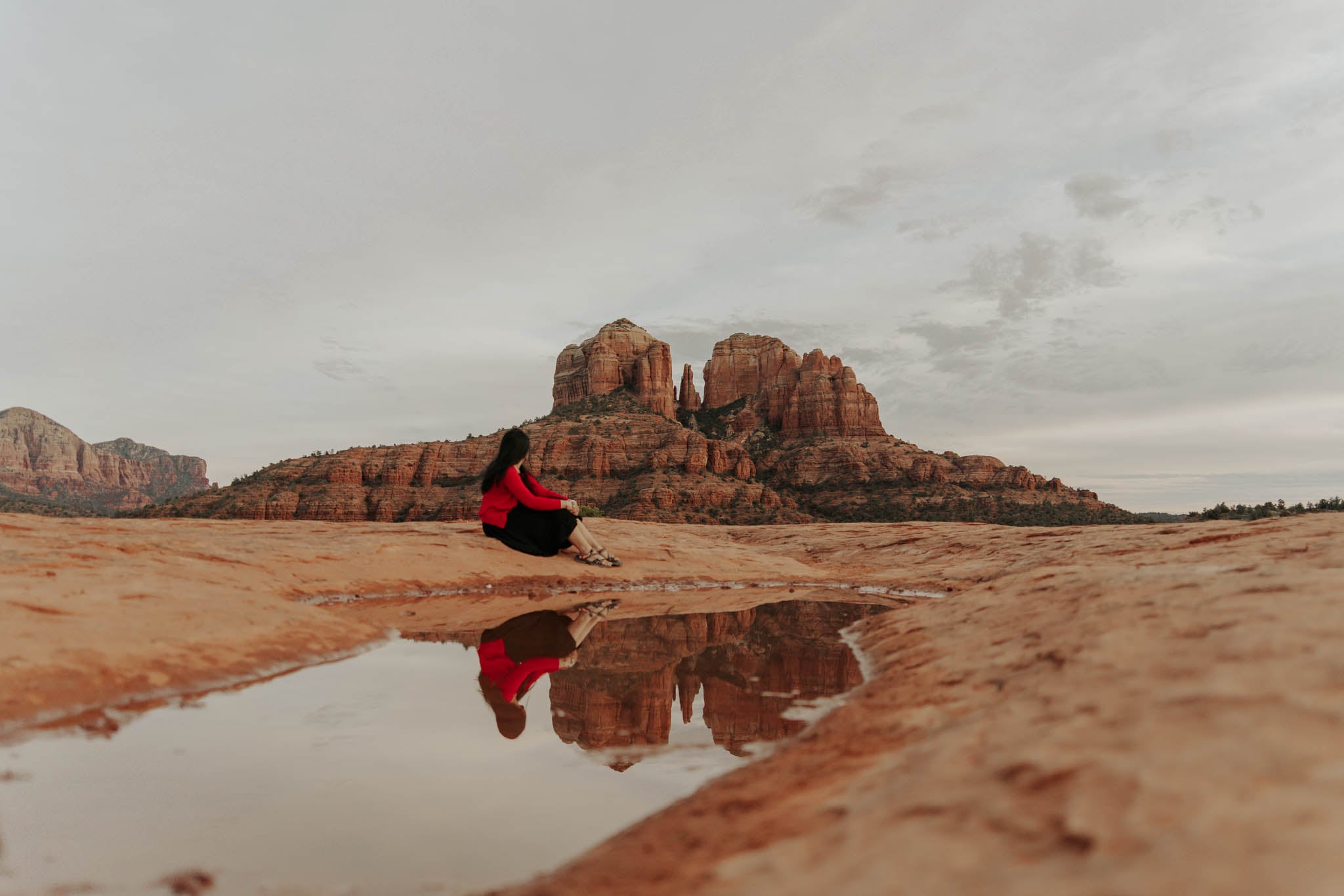 Divya Natur Artist sitting calmly in front of Cathedral rock in Sedona